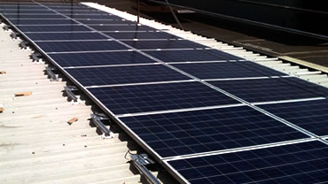 Solar panels on a roof, By Combining solar PV, Biomass and LED lighting massive savings can be made